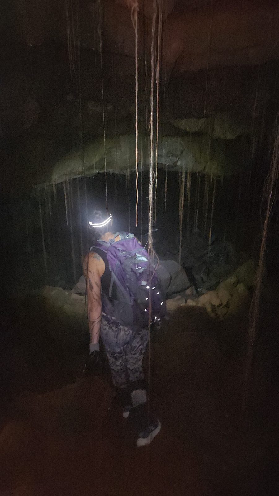 Jessie with a headlamp exploring the lava tube interior